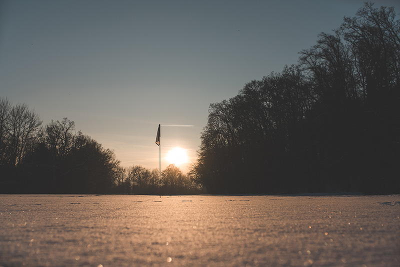 Verschneiter Golfplatz mit Flagge